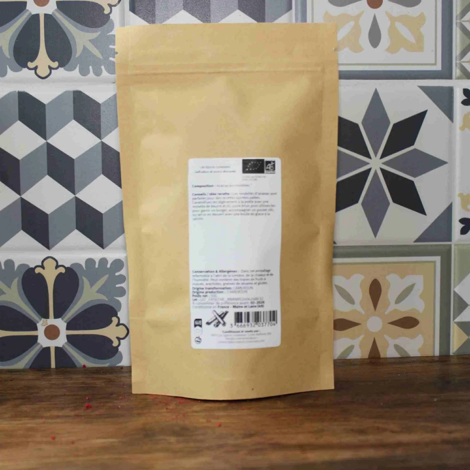 Paquet refermable sur fond de carreaux décoratifs géométriques pour cuisine ou épicerie moderne.