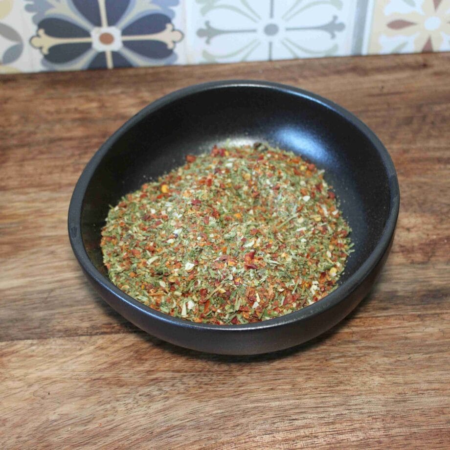 Assortiment coloré dherbes et dépices dans un bol noir sur une table en bois fond de carreaux décoratifs