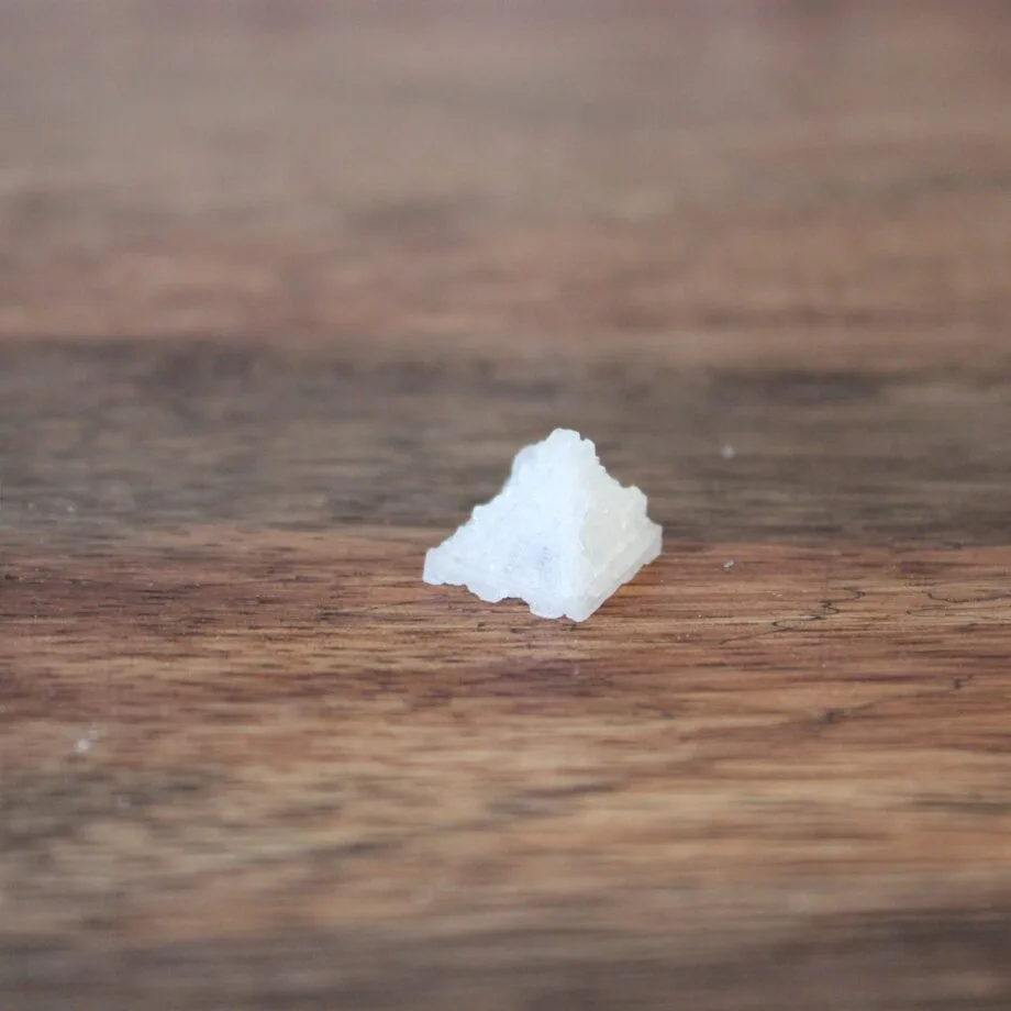 Cristal de sel en forme de pyramide sur une table en bois