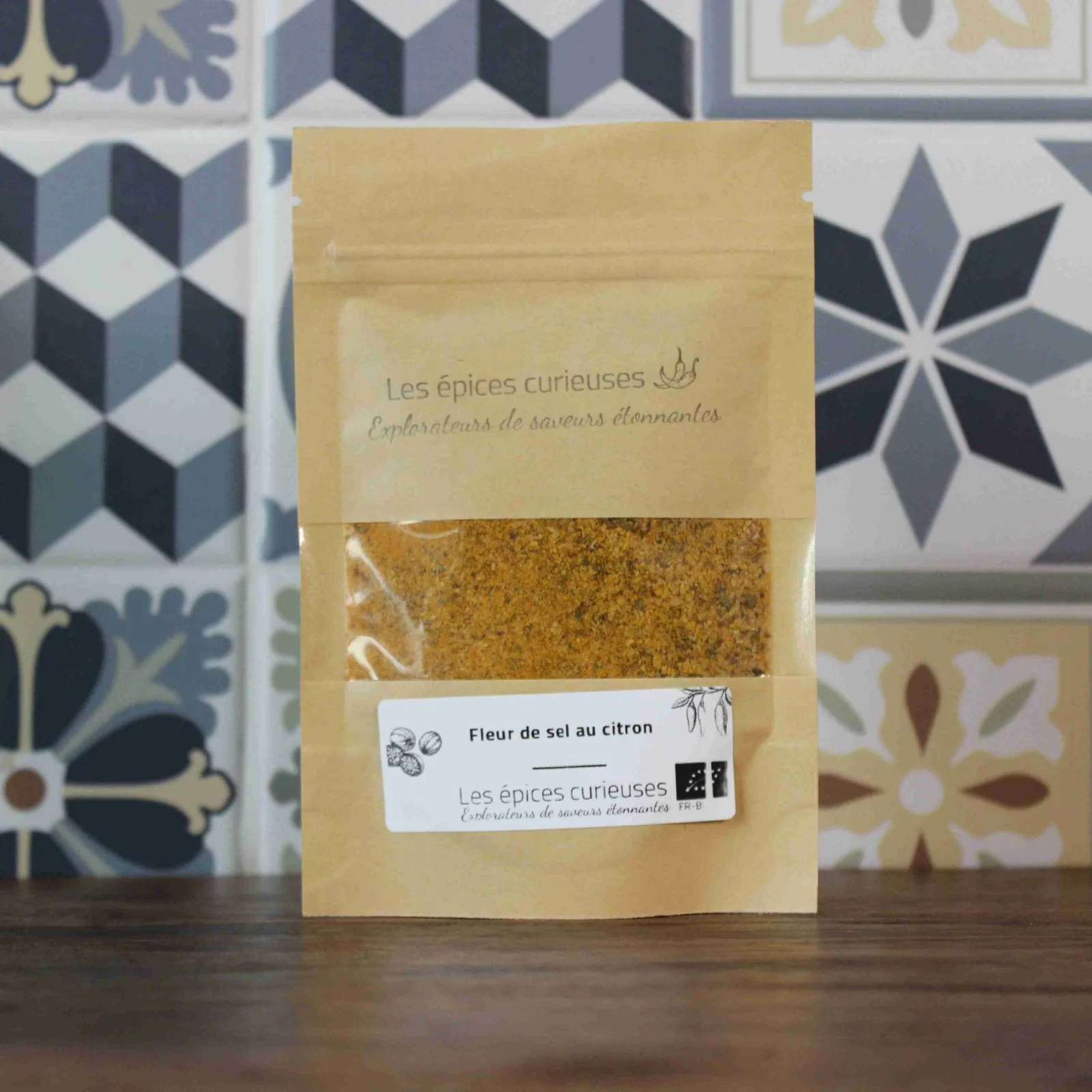 Sachet de fleur de sel au citron de Les épices curieuses sur fond de carrelage décoratif.