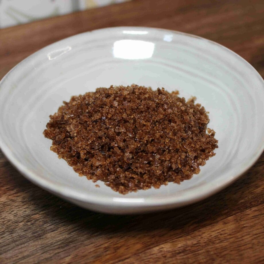 Sucre brun dans une assiette blanche sur une table en bois