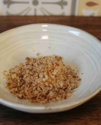 Sel assaisonné maison dans un bol blanc sur une table en bois. Idéal pour agrémenter vos plats culinaires.