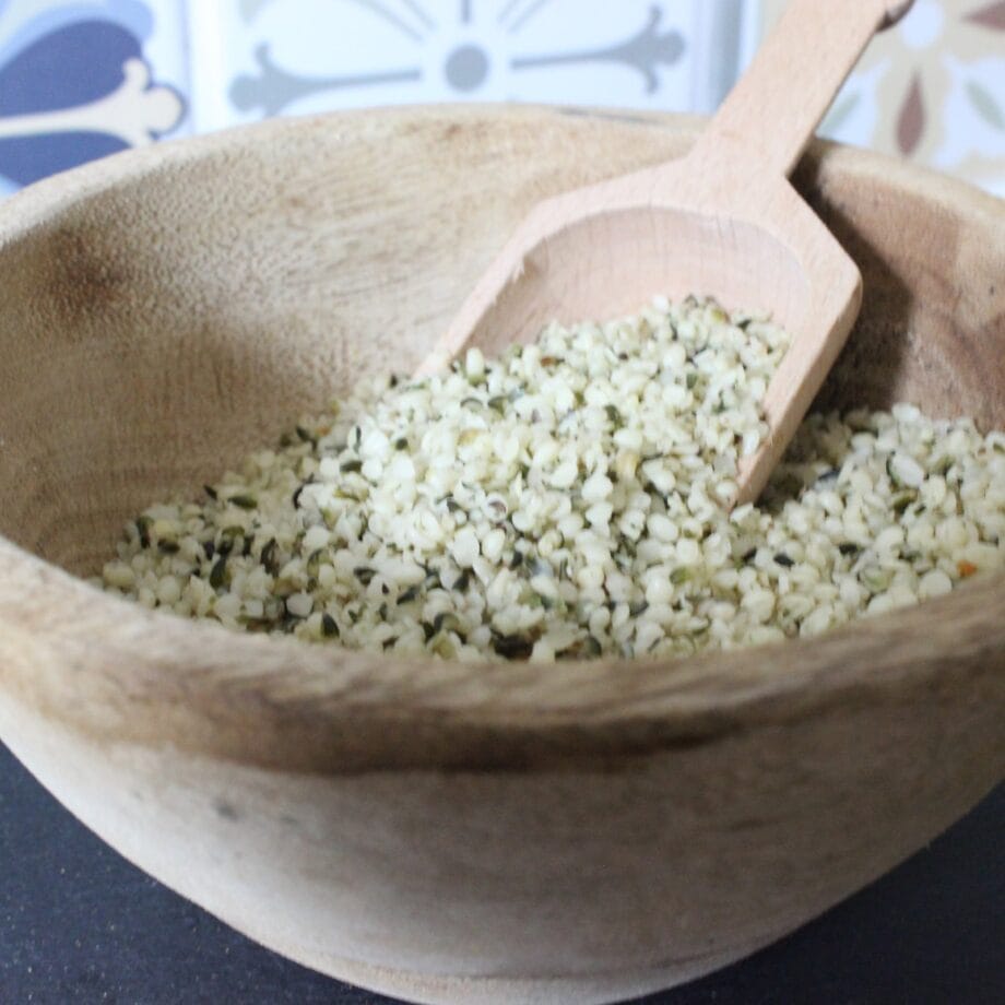 Bol en bois rempli de graines de chanvre biologiques avec cuillère en bois. Source de protéines et d'oméga-3.