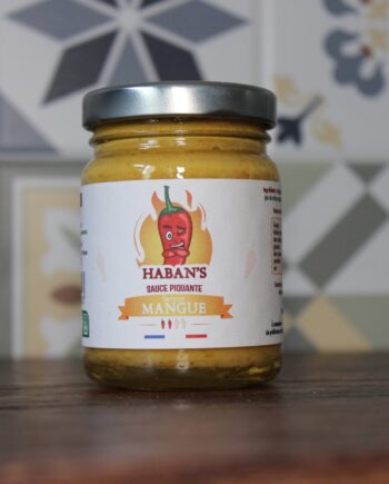 Pot de sauce piquante mangue Haban's sur fond de carrelage, saveur exotique et épicée.