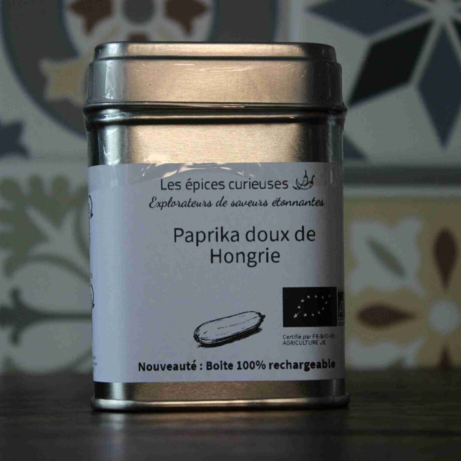 Boîte de paprika doux bio de Hongrie en métal rechargeable signée Les épices curieuses, sur fond de motifs colorés.