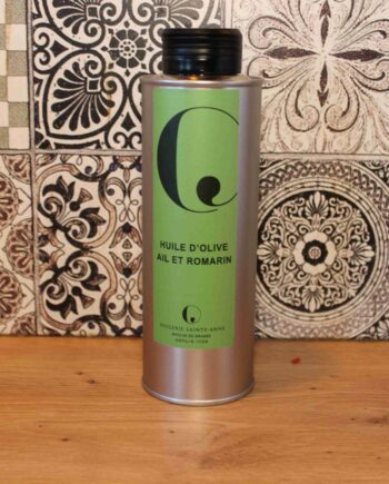 Bouteille d'huile d'olive ail et romarin devant un carrelage décoratif, cuisine élégante.