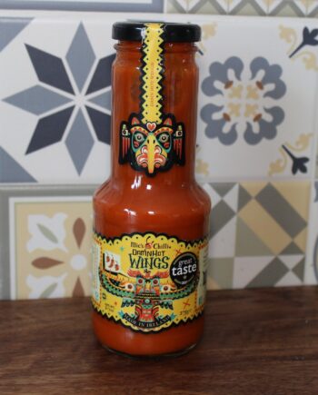 Sauce piquante Mic's Chili Damn Hot Wings sur une table en bois avec un fond de carrelage artistique.