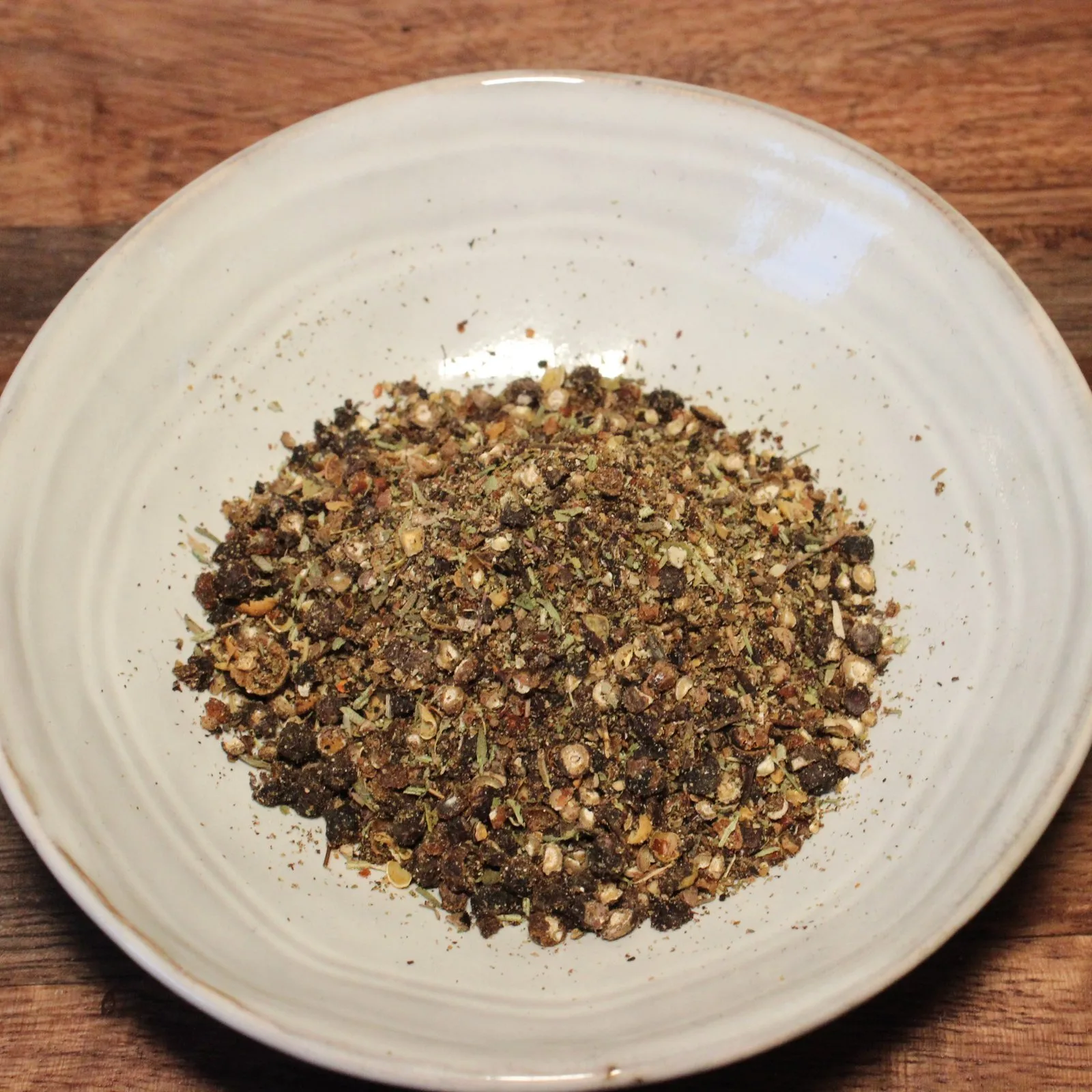 Assiette de mélange d'épices complet sur une table en bois, parfait pour rehausser les saveurs culinaires.