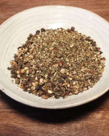 Bol d'épices mélangées sur une table en bois, idéal pour assaisonner vos plats et rehausser la saveur.