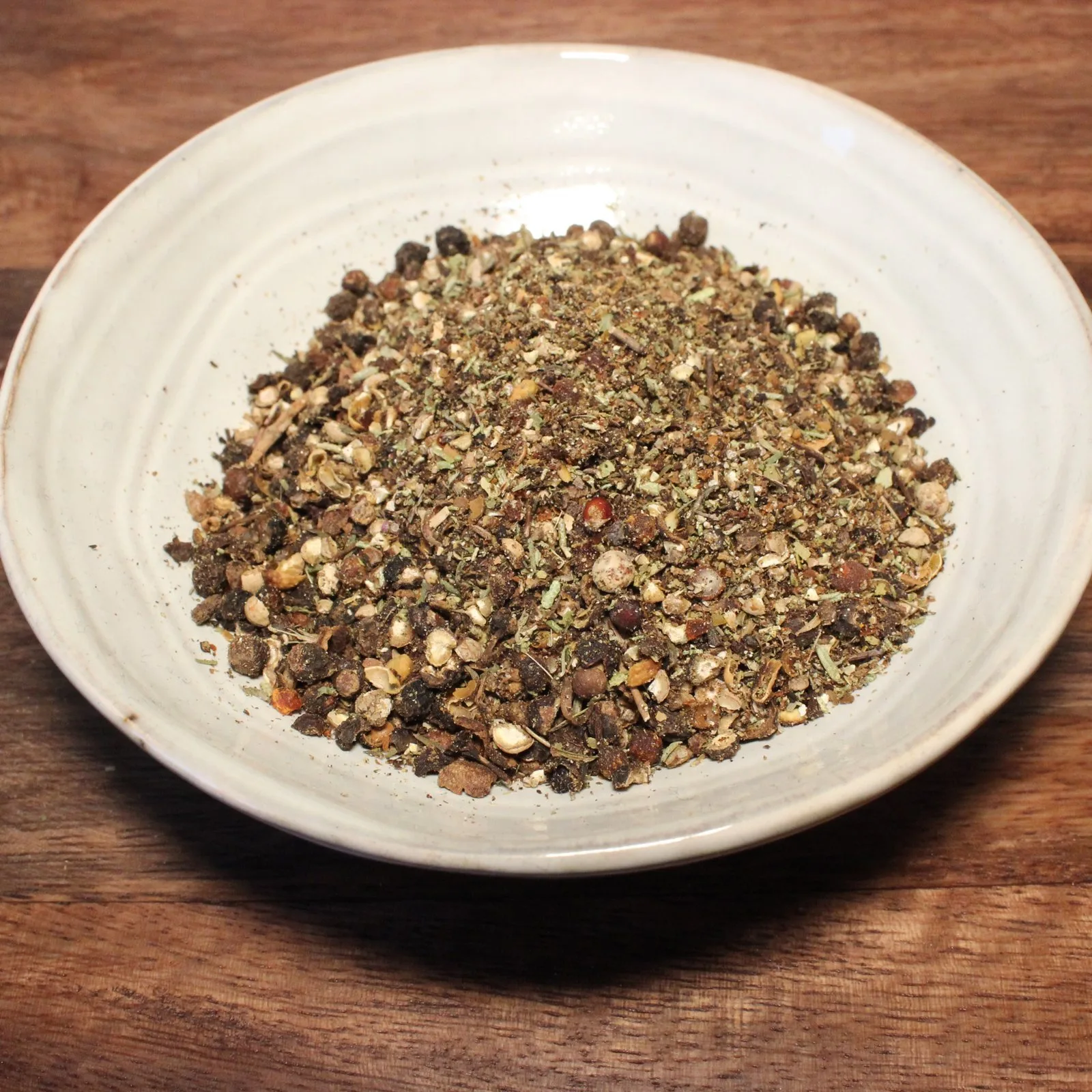 Bol d'épices mélangées sur une table en bois, idéal pour assaisonner vos plats et rehausser la saveur.