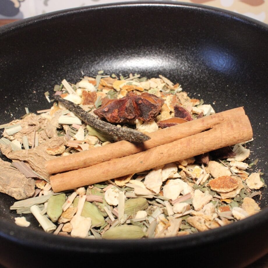 Un mélange dépices aromatiques dans un bol noir avec de la cannelle de lanis étoilé et des herbes séchées