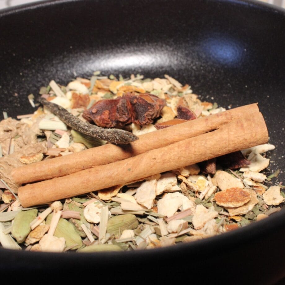 Mélange dépices en vrac avec bâton de cannelle dans une poêle noire Parfait pour infusions ou cuisine exotique