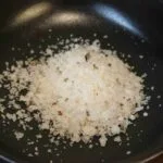 Du gros sel dans une poêle noire pour une cuisine raffinée et gourmande.