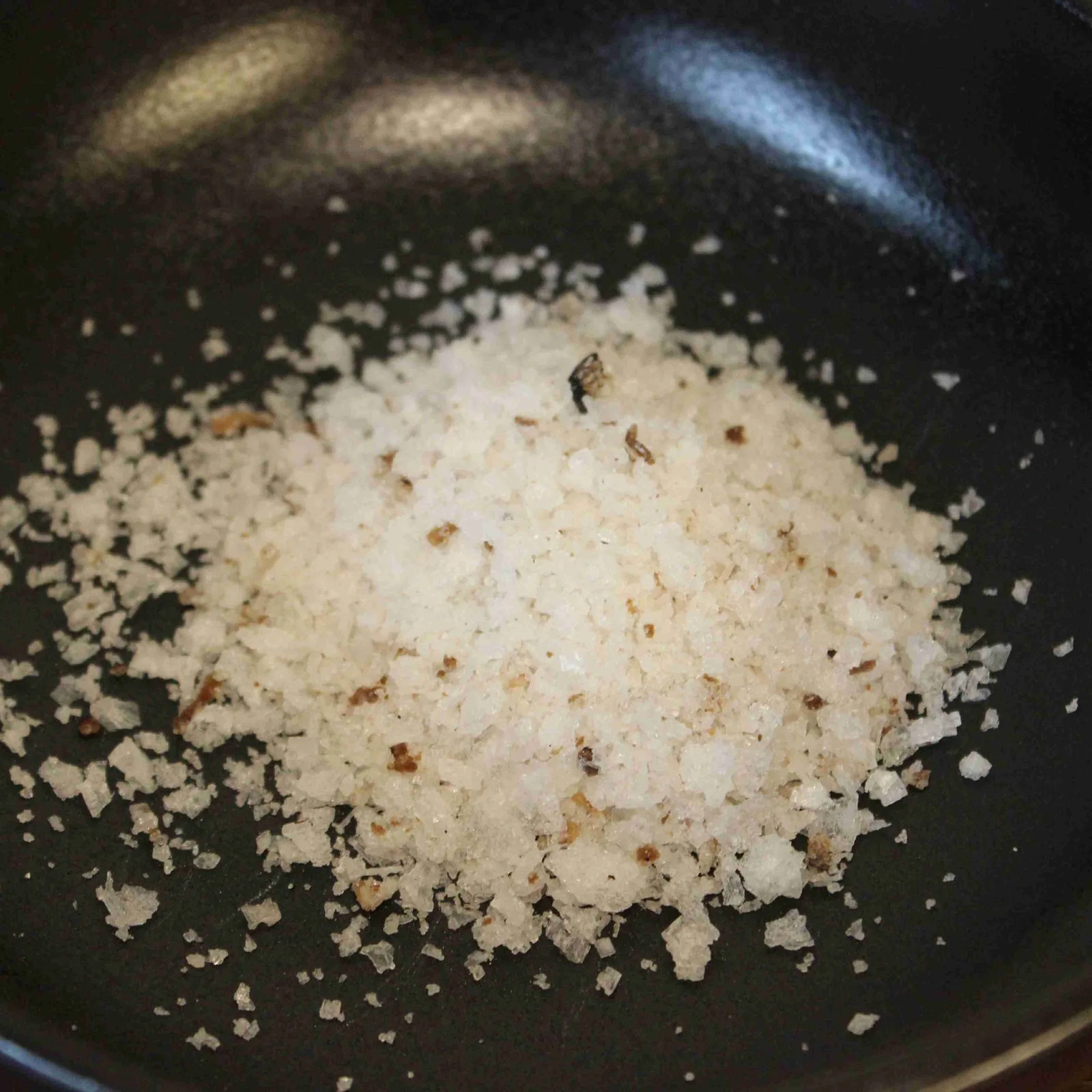 Du gros sel dans une poêle noire pour une cuisine raffinée et gourmande.