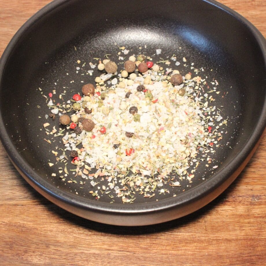 Assortiment dépices colorées dans un bol noir sur une table en bois Mélange parfait pour rehausser vos plats