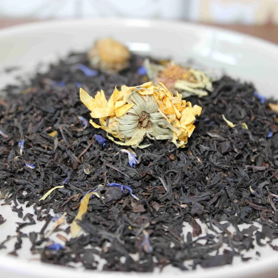 Mélange de thé noir avec fleurs séchées dans une assiette blanche prêt pour linfusion