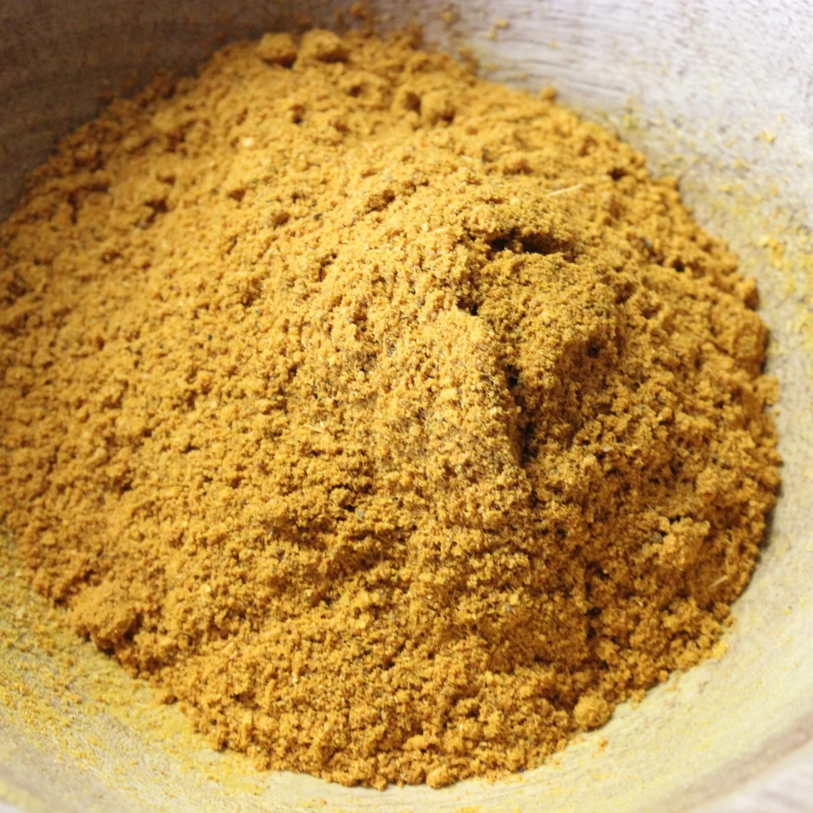 Poudre de curry épicée dans un bol, parfaite pour rehausser le goût de vos plats.