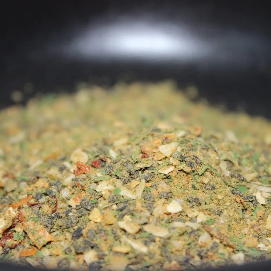 Mélange dépices colorées avec morceaux secs dherbes et de légumes idéal pour assaisonner plats variés et intensifier saveurs