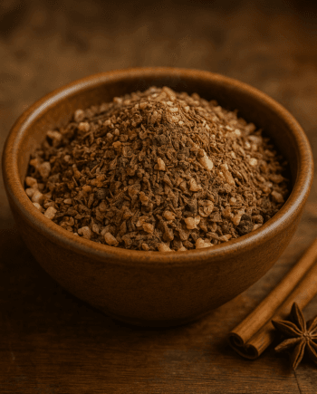 Bol de granola épicé avec bâtons de cannelle et badiane sur fond en bois. Idéal pour un petit déjeuner savoureux.