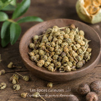 Grains de poivre en vrac dans un bol en bois sur une table rustique, utilisés pour épicer les plats culinaires.